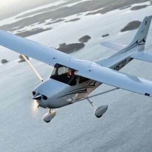 A Cessna 172 in flight above a coastline