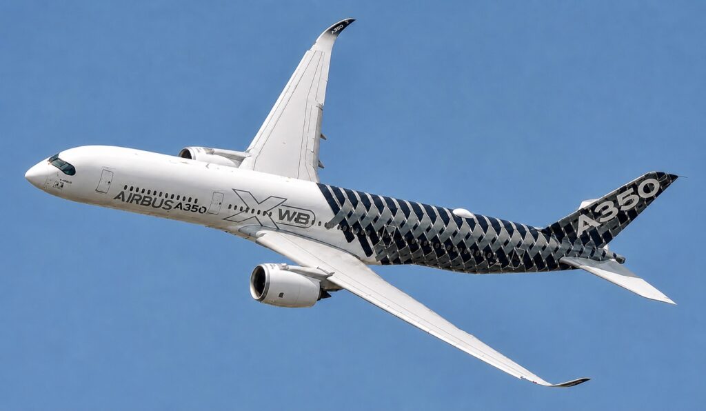 An Airbus A350 in flight against a clear blue sky